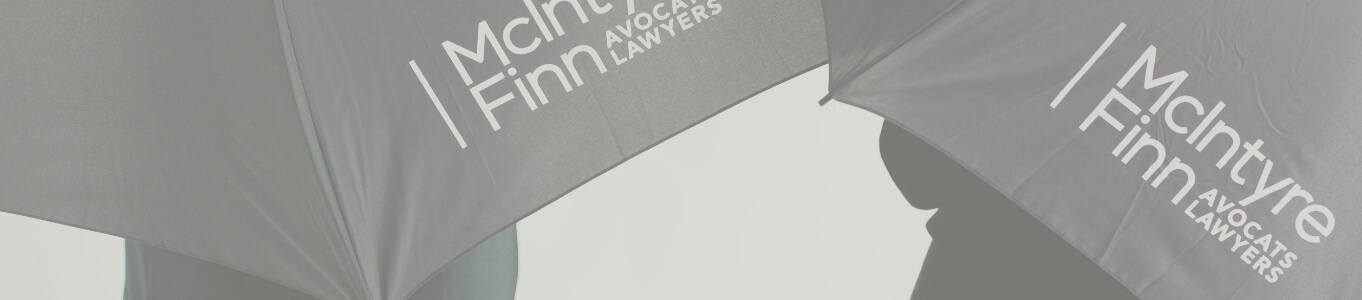 Deux personnes tenant des parapluies avec le logo McIntyre Finn.