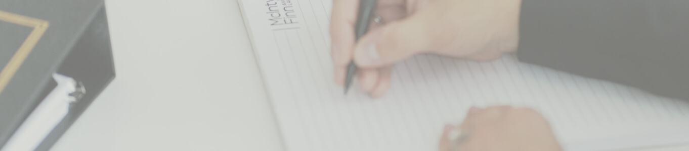 Hand holding a pen over legal pad